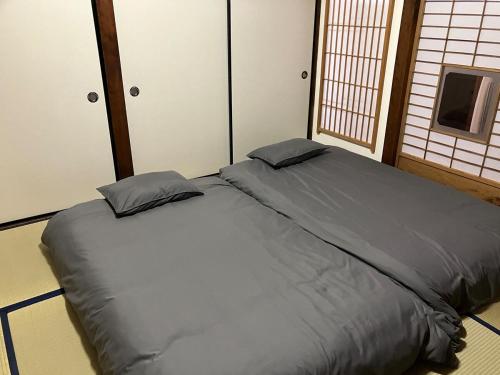 een groot bed met 2 kussens in een kamer bij Guest House景 in Kumamoto