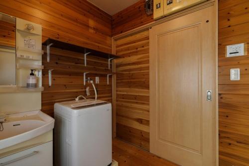 een badkamer met een toilet, een wastafel en een deur bij Guest House景 in Kumamoto