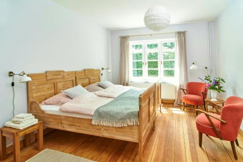 a bedroom with a wooden bed and a table and chairs at Artist's Studio House In Aukrug Nature Park in Meezen