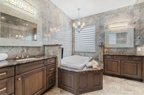 un baño con bañera y lavabo en 9 Willow Green Dr, en Cocoa Beach