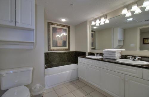 a bathroom with two sinks and a tub and a toilet at Barefoot Yacht Club Villas - 1-805 in Myrtle Beach
