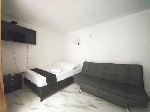 a bedroom with a bed and a couch at Casa Eclat in Medellín