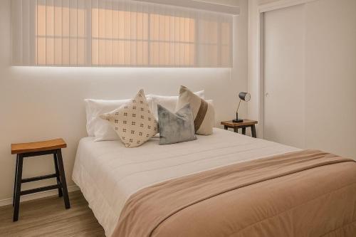 una camera da letto con un letto con cuscini e una finestra di Bright & Cozy Modern Space Near Downtown a Bakersfield