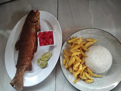a plate of food with fish and fries and rice at Finca la Rosita in Tulcán