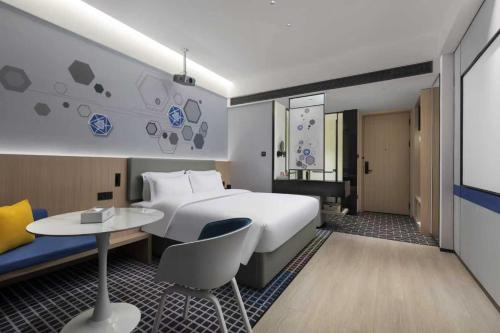 Una habitación de hotel con una cama grande y una mesa. en Microtel by Wyndham Anshun Xixiu, en Anshun