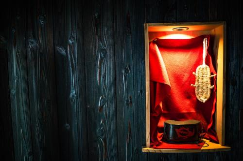 a wardrobe with a red shirt and a belt and a cup at A 270-year-old soy sauce maker and a 100-year-old house collaborate to create Kamebishi-tei in Higashikagawa