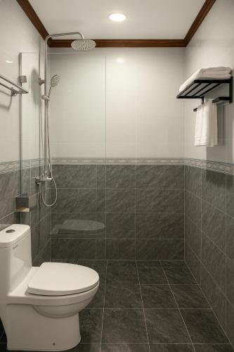 a bathroom with a toilet and a glass shower at Villa Khili Phousi in Luang Prabang