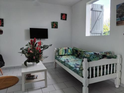 Una sala de estar con un sofá y un televisor. en Résidence belle place, en Saint-François