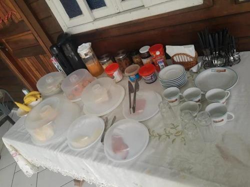 a table with plates and cups and dishes on it at Brayan`s House in Ilha do Mel