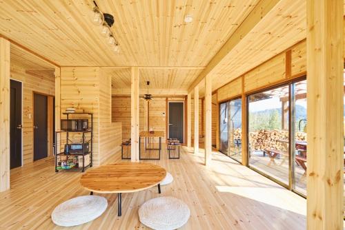 Una habitación de madera con una mesa y sillas de madera. en SHELTER君津 星が降りそそぐ千葉県Villa 最大8名 都心から70分 吹抜け貸切サウナ 雨でもBBQ 天体観測, en Kimitsu