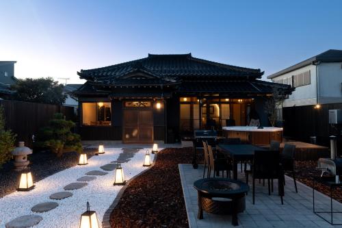 a patio with a table and chairs and a building at 陽和リトリート in Tateyama