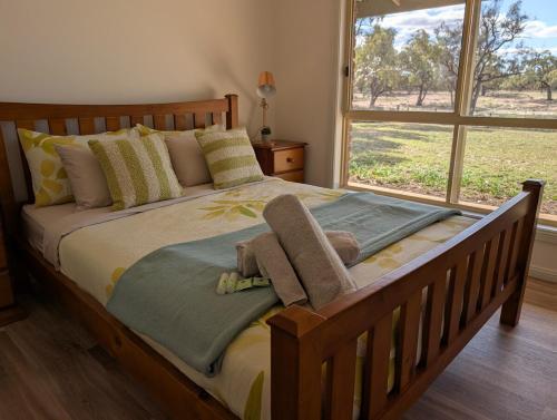 - une chambre avec un lit en bois et une grande fenêtre dans l'établissement Willa Villa Bush Retreat - Gol Gol, à Gol Gol