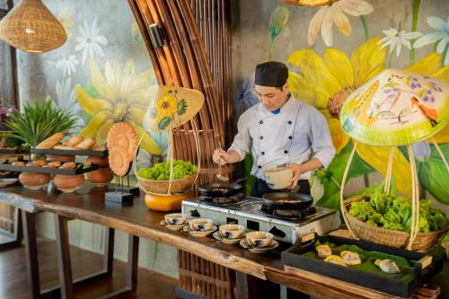 Un chef preparando comida en una estufa en un restaurante. en The Signature Hotel Nha Trang, en Nha Trang