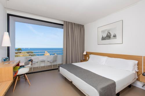 a bedroom with a bed and a view of the ocean at Gran Hotel Reymar in Tossa de Mar