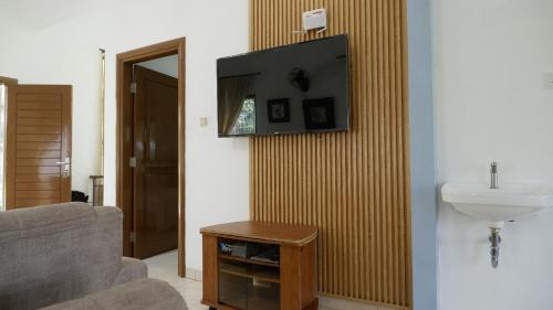 a living room with a sink and a television on a wall at Villa Dalia Puncak Nc3-31 in Cikundul