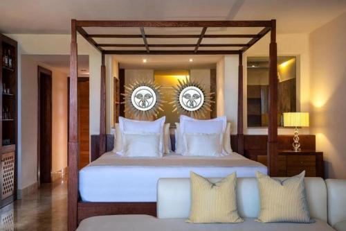 una camera da letto con un letto grande e un divano di Excellence Playa Mujeres- All Inclusive- Adults Only a Cancún