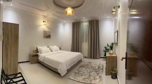 a bedroom with a white bed and a bathroom at شقة Noya غرفة وصاله بدخـول ذاتي in Taif