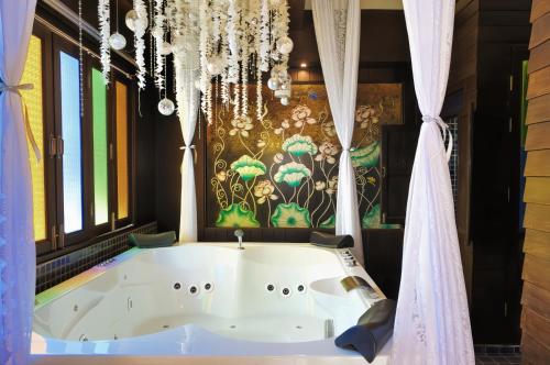 eine Badewanne in einem Badezimmer mit einer bunten Wand in der Unterkunft Singha Montra Lanna Boutique Style Hotel in Chiang Mai