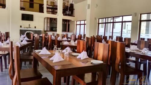 a restaurant with wooden tables and chairs with napkins on them at Talawakele Rest House in Nuwara Eliya