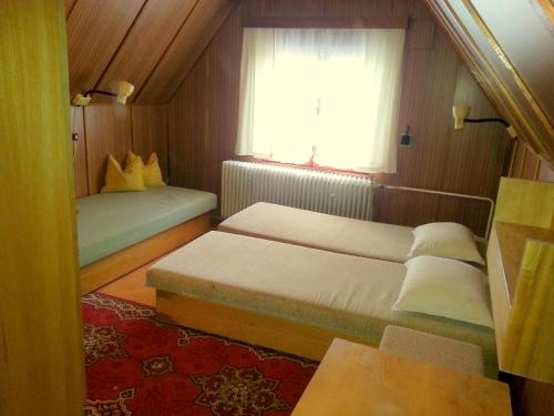 um pequeno quarto com 2 camas e uma janela em Chata Salaš em Mlynčeky