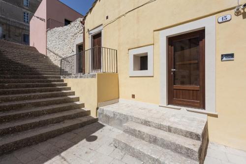 a set of stairs next to a building with a door at Giardino Sul Duomo in Ragusa