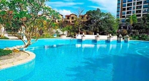 a large blue swimming pool in a city at Howard Johnson by Wyndham Life Changrong in Qinzhou