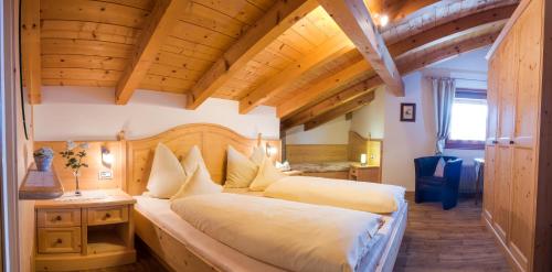 Un dormitorio con dos camas en una habitación con techos de madera. en Apartment Suliva, en Santa Cristina Valgardena