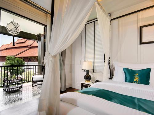 a bedroom with a bed and a balcony at Siri Village Chiang Mai in Chiang Mai