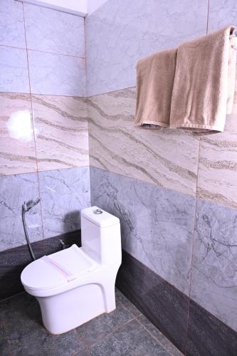 a bathroom with a toilet and a towel at The Nature's Nest in Attigundi