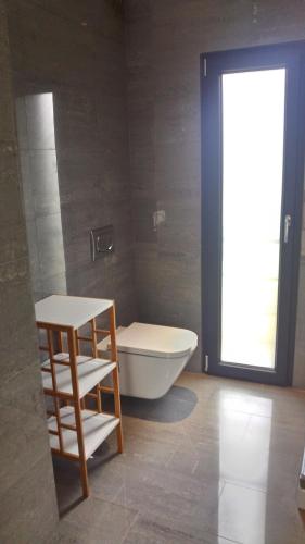 a bathroom with a tub and a toilet and a window at Casa Rio da Prata in Aldeia do Meco