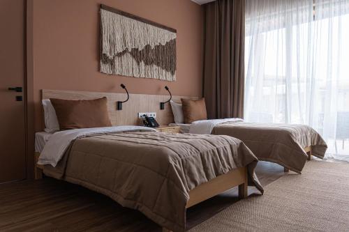 a bedroom with two beds and a large window at Nammu Spa and Wellness in Dubun