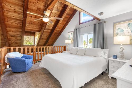 a bedroom with a white bed and a crib at 8156 Ridgewood Ave in Cape Canaveral
