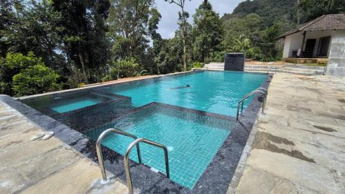 a swimming pool with blue water in a house at The Nest bettathur, Coorg in Madikeri