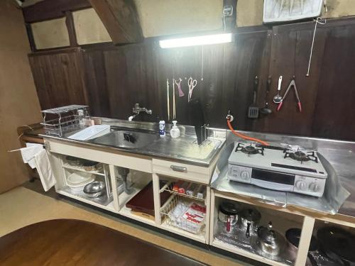 a kitchen with a sink and a stove at dannouraしげの里 1棟貸切 築120年古民家 バーベキュー 海が見える駐車場無料 in Takamatsu