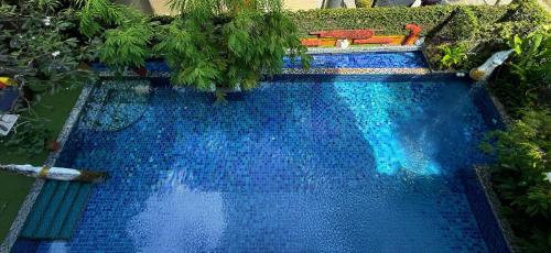 an overhead view of a blue swimming pool with trees at Singha Montra Lanna Boutique Style Hotel in Chiang Mai