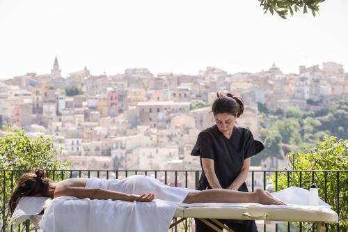 a woman getting a massage from a woman laying on a table at Giardino Sul Duomo in Ragusa