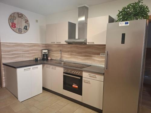 a kitchen with white cabinets and a refrigerator at Sobe Nobiles in Draganići