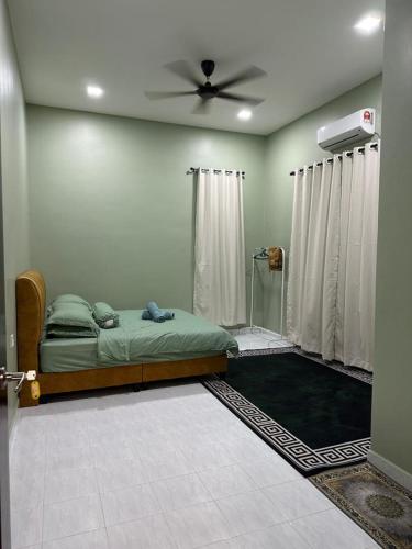 a bedroom with a bed and a ceiling fan at Casa Amethyst in Kuala Terengganu