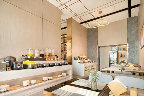 a kitchen with a table and a counter with food at Poltton International Service Apartment Shanwei Urban District High-speed Railway Station in Shanwei