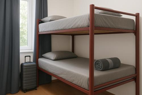 twee stapelbedden in een kamer met een koffer bij Ozi Inn Backpackers - Perth -Valid International Passport Required in Perth