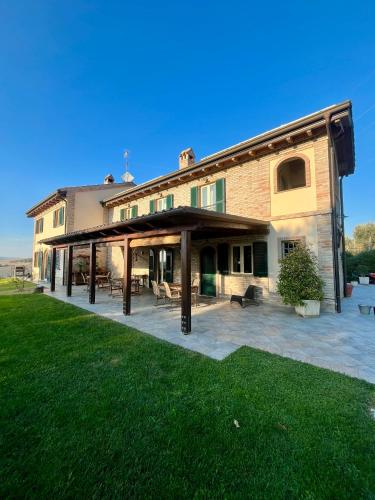a large building with acovered patio in the yard at Farm Ca Nick in Fermo