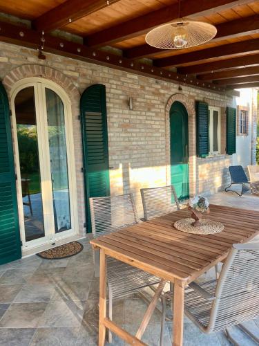 a wooden table and chairs on a patio at Farm Ca Nick in Fermo