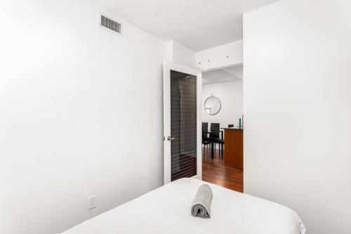 1 dormitorio con paredes blancas y 1 cama blanca en Luxe 3BR 2 Bath Condo Steps from Square one Mall, en Mississauga