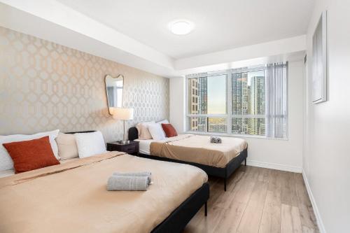 Una habitación de hotel con dos camas y una ventana. en Luxe 3BR 2 Bath Condo Steps from Square one Mall, en Mississauga
