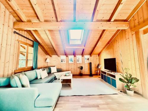 a living room with a couch and a tv at Villa Eiger Close to Grindelwald in Lütschental