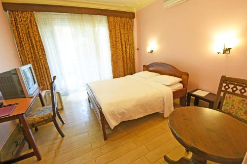 a hotel room with a bed and a table at Imperial Golf View Hotel in Entebbe