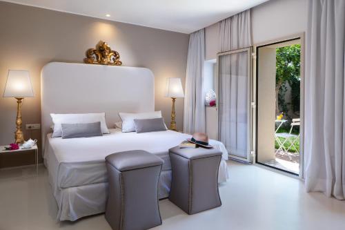 a bedroom with a large white bed and two chairs at Hotel Villa Taormina in Taormina