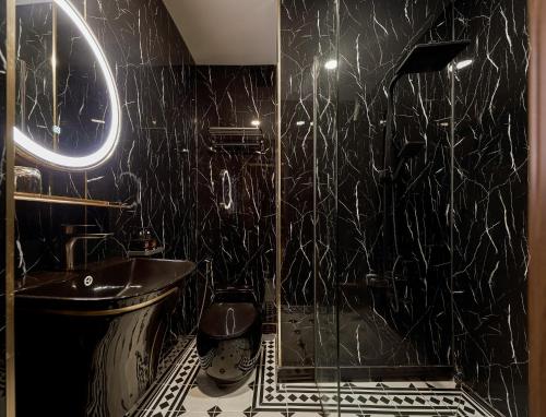 a black bathroom with a toilet and a sink at The Passion Suites Hotel & Spa in Ho Chi Minh City