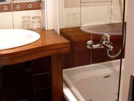 een badkamer met een wastafel en een bad bij Hotel Les Sapins in Le Ménil