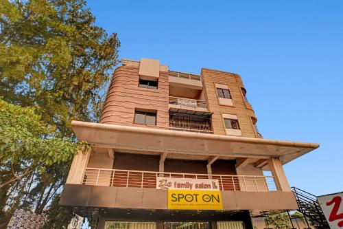 Un edificio alto con un cartel delante. en Hotel O Trinity Inn, en Nagpur